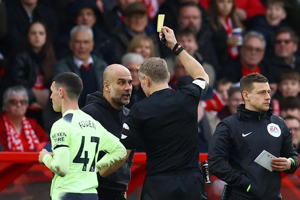 Manchester City manager Pep Guardiola is shown a yellow card by referee Graham Scott.