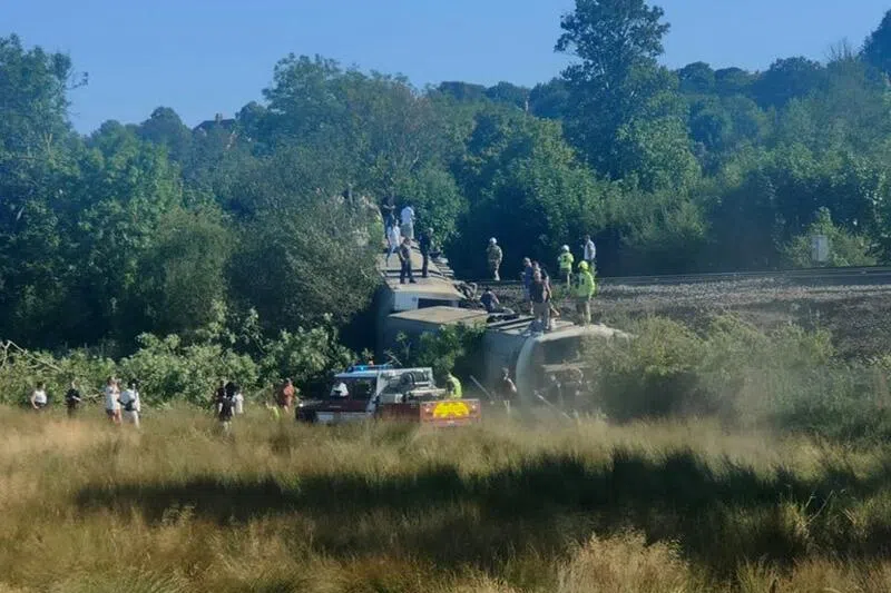 Members of the Emergency services on the carriage of a derailed train on Aug 13, near the town of Lewes, southern England.