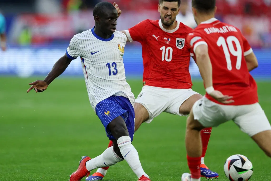 Soccer Football - Euro 2024 - Group D - Austria v France - Dusseldorf Arena, Dusseldorf, Germany - June 17, 2024 France's N'Golo Kante in action with Austria's Florian Grillitsch and Christoph Baumgartner REUTERS/Thilo Schmuelgen
