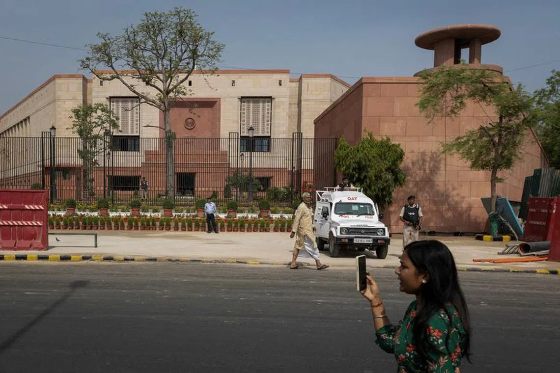 FILE PHOTO: A member of media works outside the India's new parliament building before its inauguration in New Delhi, India, May 28, 2023. REUTERS/Adnan Abidi/File Photo