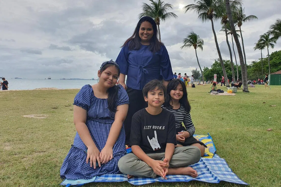 Ms Siti Hajilah Adam (standing) with her three children.
