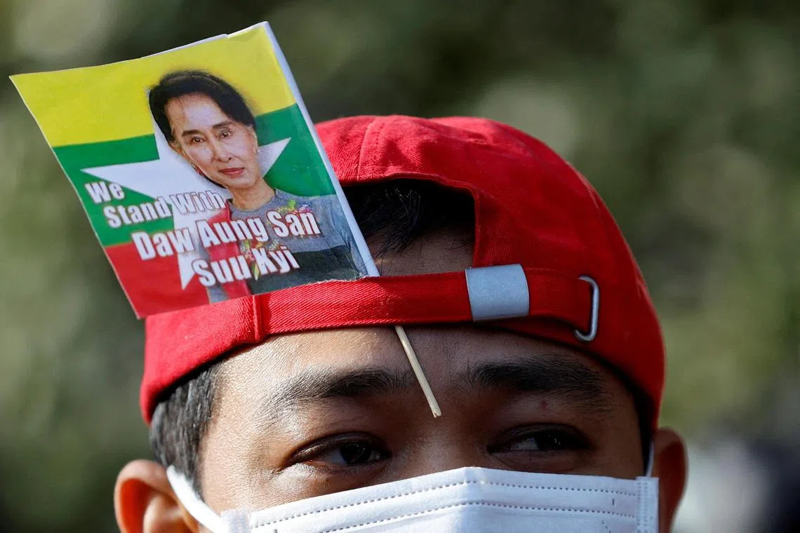 A Myanmar protester residing in Japan uses a flag with an image of deposed Myanmar leader Aung San Suu Kyi during a rally to mark the second anniversary of Myanmar's 2021 military coup.