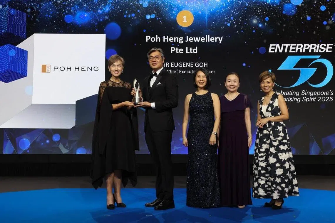 Poh Heng Jewellery group CEO Eugene Goh (second from left) receiving the top accolade at this year's Enterprise 50 Awards from Minister for Digital Development and Information Josephine Teo (left). 