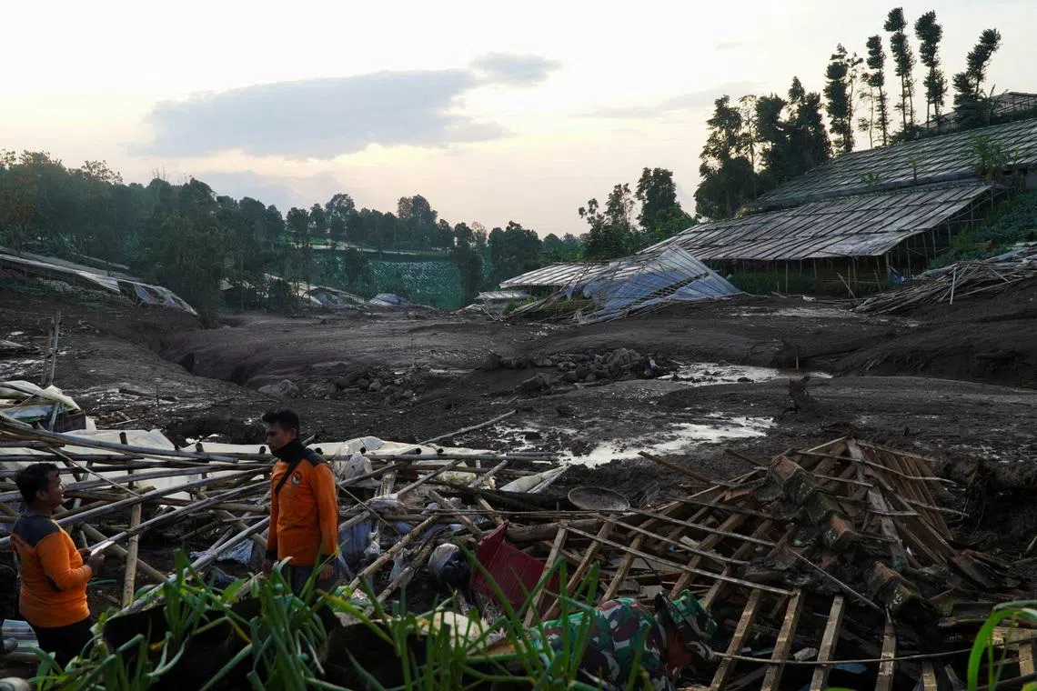 Indonesian rescue members stand near damaged houses after a landslide hit Pasirlangu village, West Bandung, West Java province, Indonesia, January 24, 2026. REUTERS/Yusep Maulana