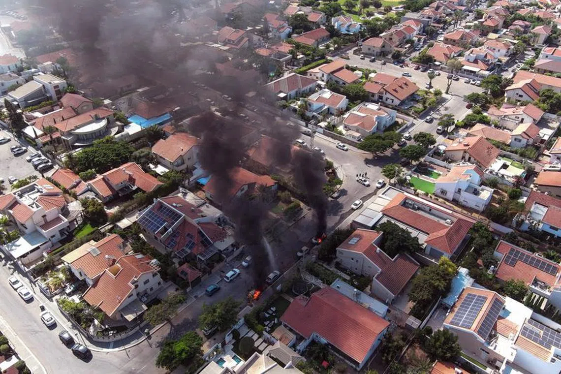 An aerial view shows vehicles on fire as rockets are launched from the Gaza Strip, in Ashkelon, southern Israel October 7, 2023. REUTERS/Ilan Rosenberg/File Photo