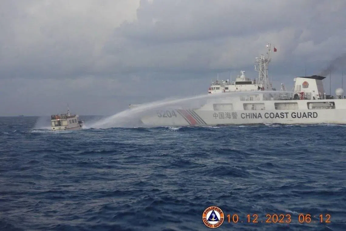FILE PHOTO: A Chinese Coast Guard ship uses a water cannon against a Filipino resupply vessel heading towards the disputed Second Thomas Shoal, in the South China Sea, December 10, 2023. Philippine Coast Guard/Handout via REUTERS/File Photo