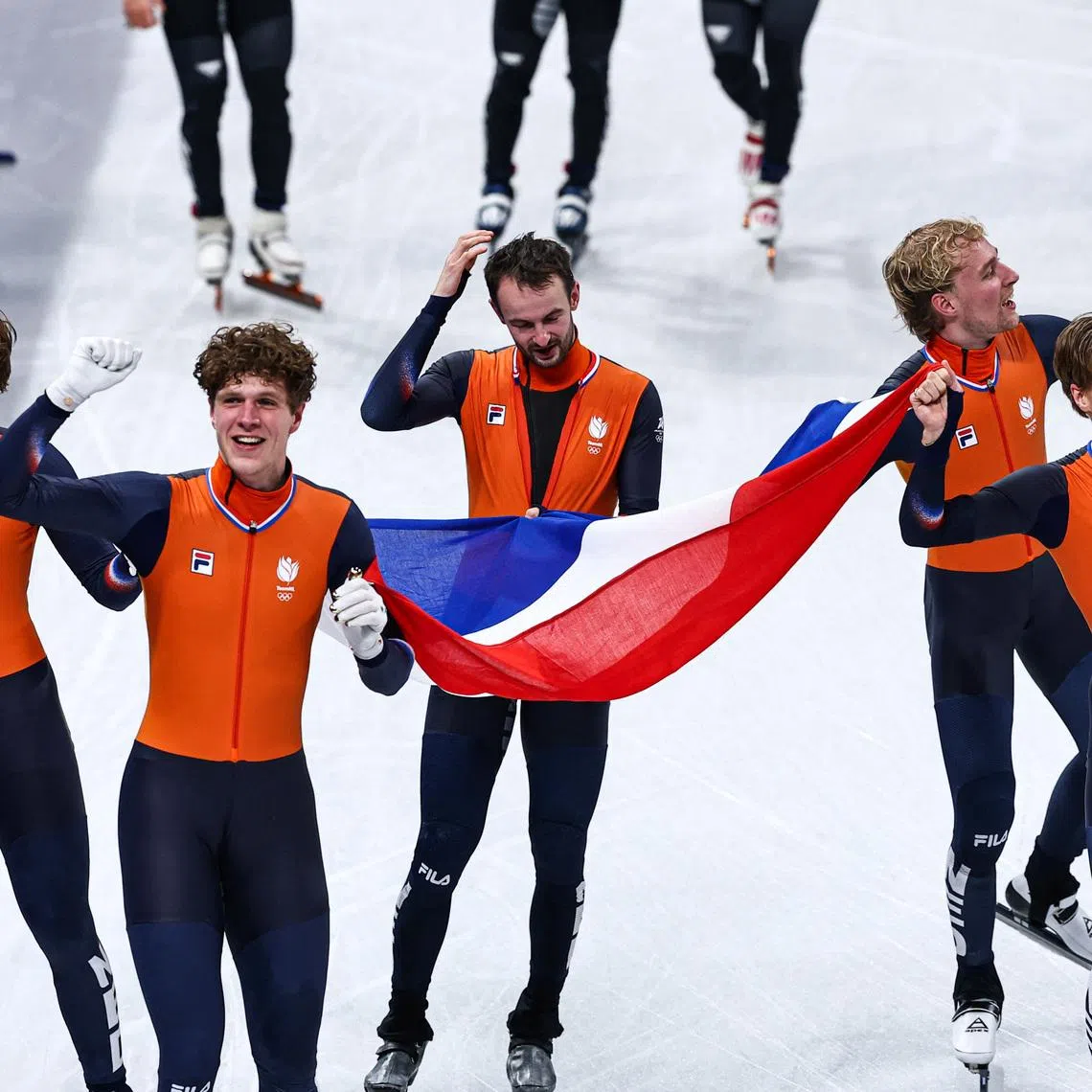 Milano Cortina 2026 Olympics - Short Track Speed Skating - Men's 5000m Relay - Finals - Milano Ice Skating Arena, Milan, Italy - February 20, 2026. Jens van 'T Wout of Netherlands, Teun Boer of Netherlands, Friso Emons of Netherlands, Melle van 'T Wout of Netherlands and Itzhak de Laat of Netherlands celebrate with their national flag after winning gold in the Men's 5000m Relay Finals REUTERS/Amanda Perobelli