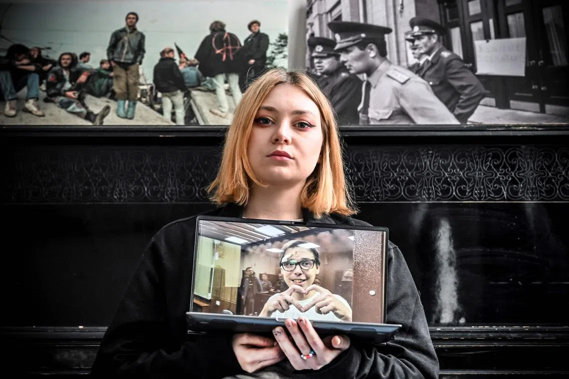 Ms Alexanda Popova shows a photo of her jailed boyfriend Artyom Kamardin.