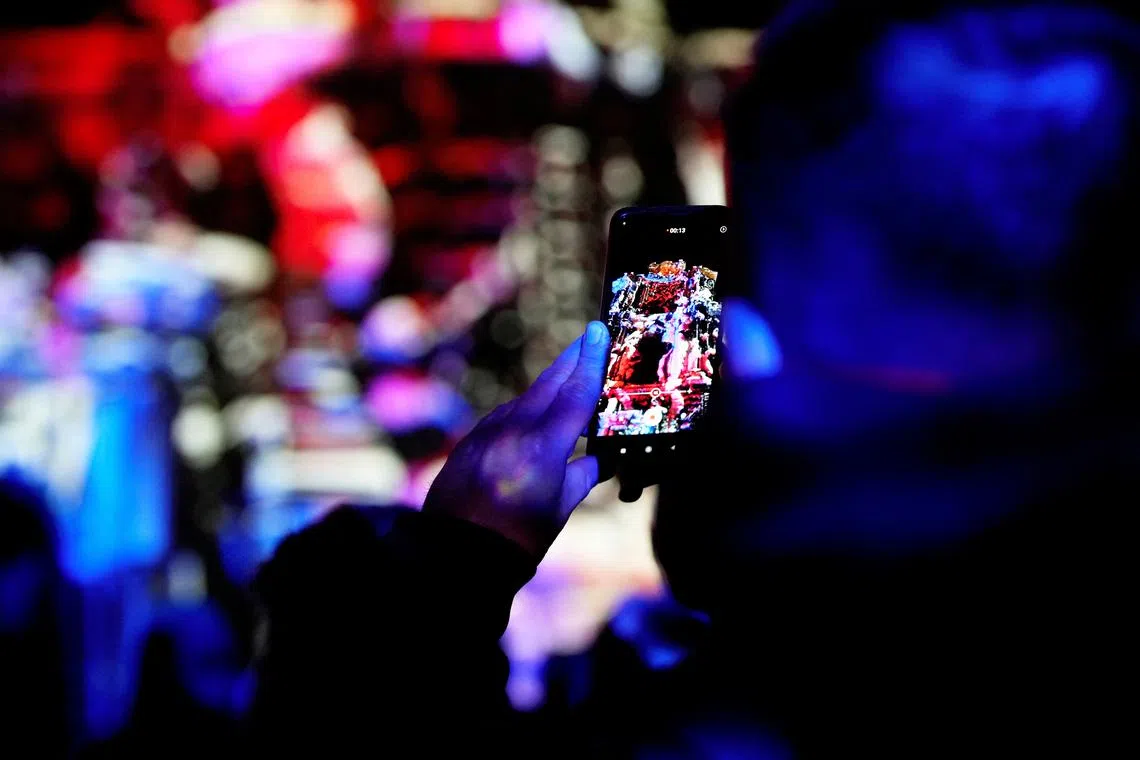 A man takes a picture of light illumination during Lithuanian capital's 700th anniversary celebration with the festival of lights in Vilnius, Lithuania  Jan 25, 2023. 