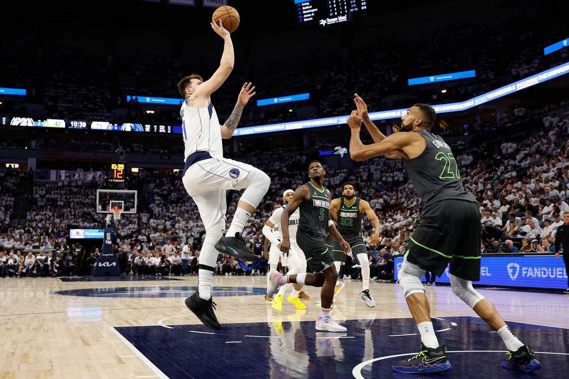 Luka Doncic of the Dallas Mavericks shoots the ball against Rudy Gobert of the Minnesota Timberwolves during the third quarter in Game 5 of the NBA Western Conference Finals.