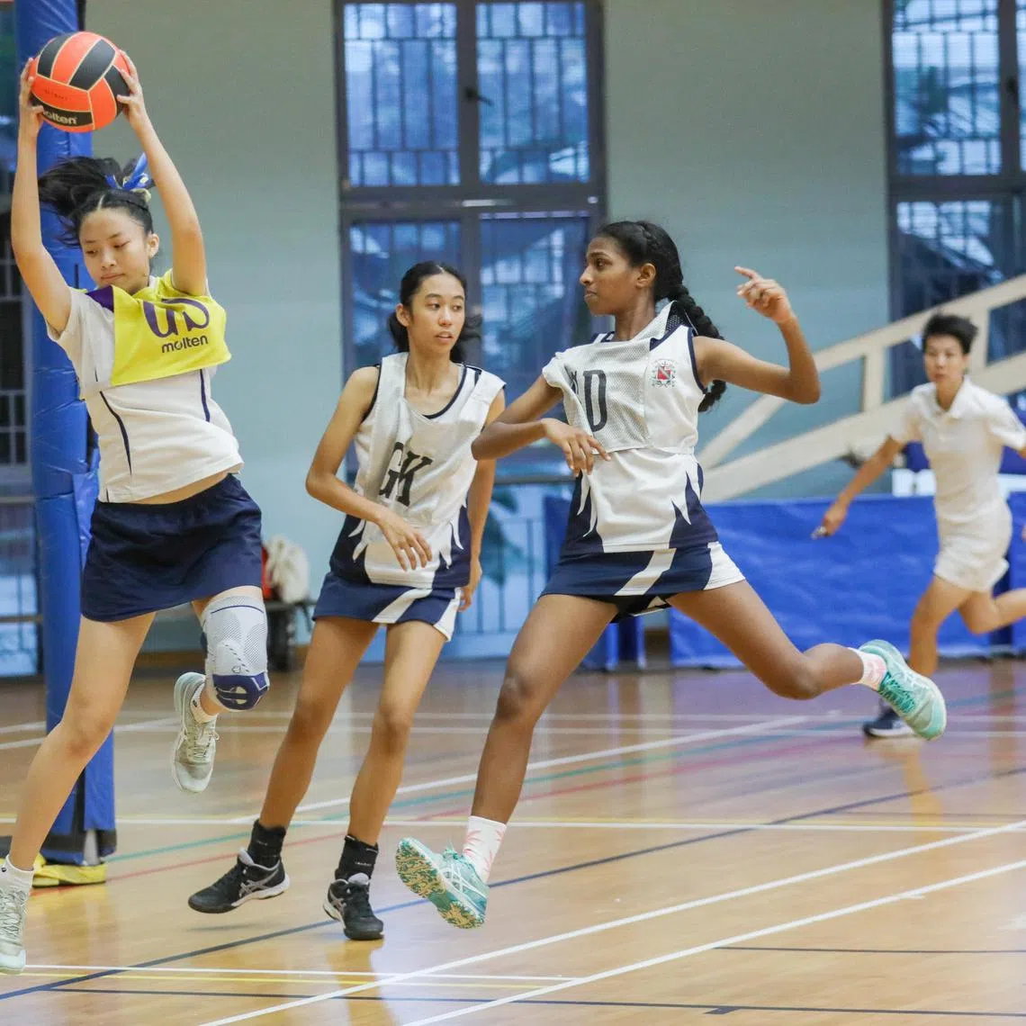 ST20240815_202489000406/rcnet15/Luther Lau/Rebekah Chia/ Action shots of Sarah Lim(In yellow from MGS), Zyra Helina Jocson, (middle) and Kaaviya D/O Kabil Dhew(Right from CHIJ) Participating in the Netball Finals C division. Taken at Jurong sports Hall.