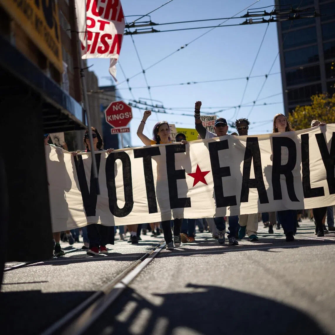 People holding a banner at a ‘No Kings: Vote Early’ protest in San Francisco on Oct 17.