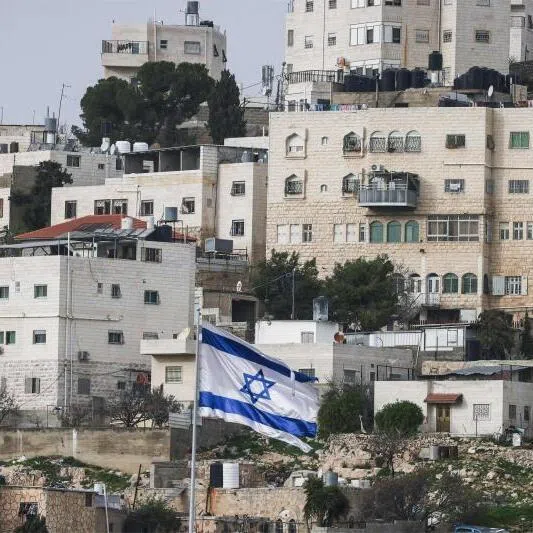 An Israeli flag fluttering above an Israeli settlement, with Palestinian buildings in the background, in the Israeli-occupied West Bank city of Hebron on Feb 9, 2026.