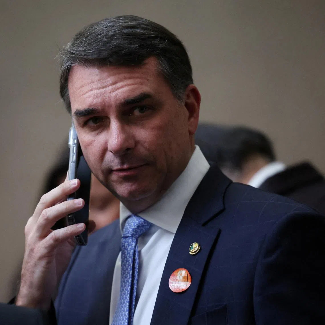 FILE PHOTO: Senator Flavio Bolsonaro uses his phone in Brasilia, Brazil, May 12, 2026.REUTERS/Adriano Machado/File Photo