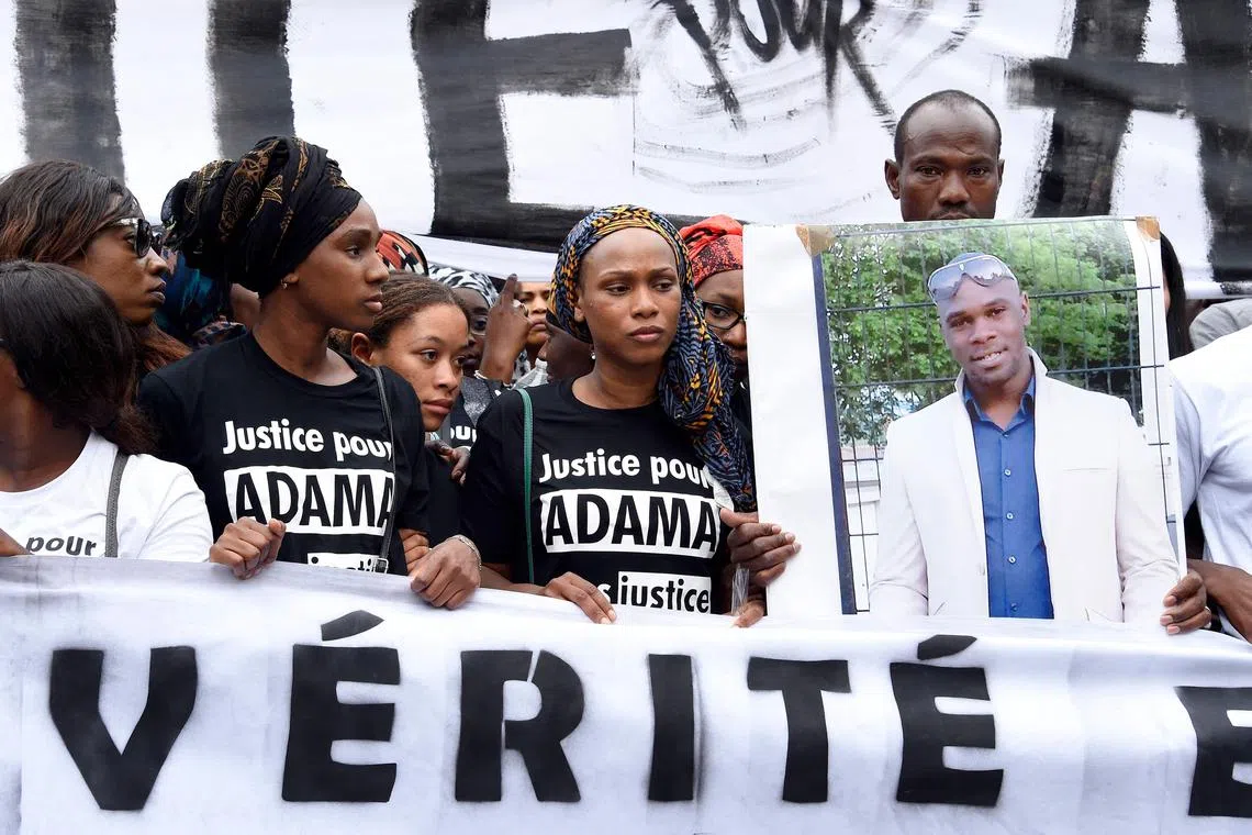 (FILES) Adama's sister, Assa (2nd R) looks on next to a man holding a placard with a portrait of Adama Traore as protesters hold a banner reading "Truth" during a march to protest at the death of Adama Traore, in Paris, on July 30, 2016. The magistrates in charge of the judicial investigation into the July 2016 death of Adama Traore, which has become a symbol of the violence and racism of which the police are accused, have dismissed the case against the French gendarmes who arrested him, AFP learned on September 1, 2023 from lawyers on both sides. Lawyer Yassine Bouzrou, who is representing the family of the young black man who died at the age of 24 and has long been critical of the way the investigation was conducted, posted on Instagram that he was appealing the decision. (Photo by DOMINIQUE FAGET / AFP)
