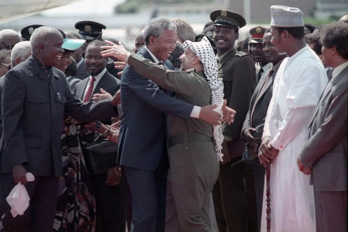 FILE PHOTO: Nelson Mandela (L) is embraced by PLO leader Yasser Arafat as he arrives at Lusaka airport February 27, 1990.  REUTERS/Howard Burditt/File Photo