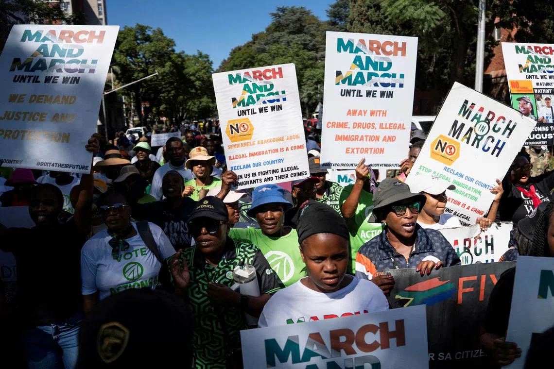 FILE PHOTO: Members of civil society groups and human rights organisations hold placards as they take part in a march calling for stronger government action against illegal immigration in Pretoria, South Africa, April 28, 2026. REUTERS/Ihsaan Haffejee/File Photo
