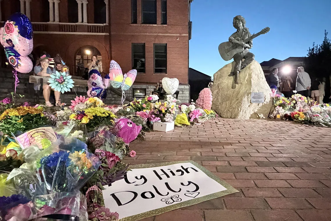 Mourners pay their respects to Dolly Parton after the announcement of her passing, at the Dolly Parton Statue in downtown Sevierville, Tennessee, U.S., August 25, 2026. Picture taken with a mobile phone. REUTERS/Kevin Fogarty