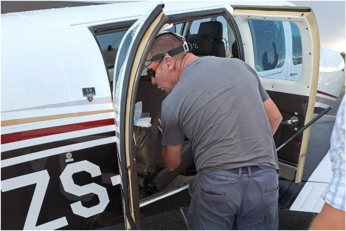 A snake catcher looking for the Cape cobra in the Beechcraft Baron 58 aircraft.