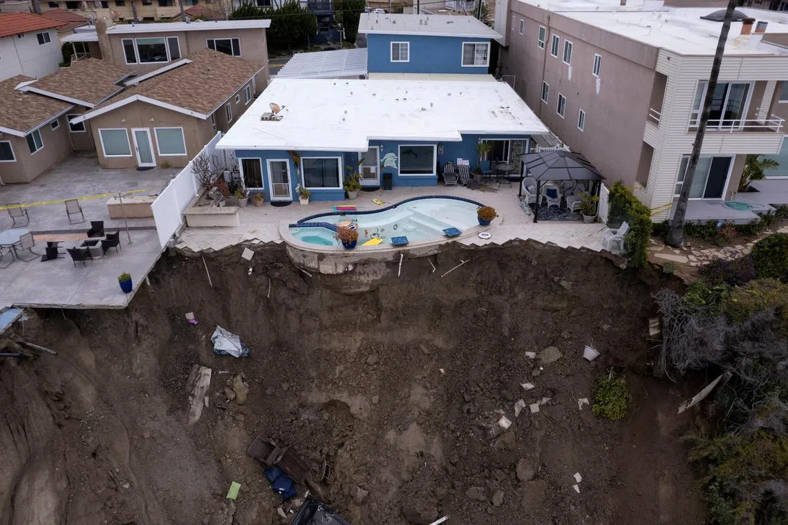 A backyard pool is left hanging on a cliffside after torrential rain brought havoc on the beachfront town of San Clemente, California, on March 16, 2023.