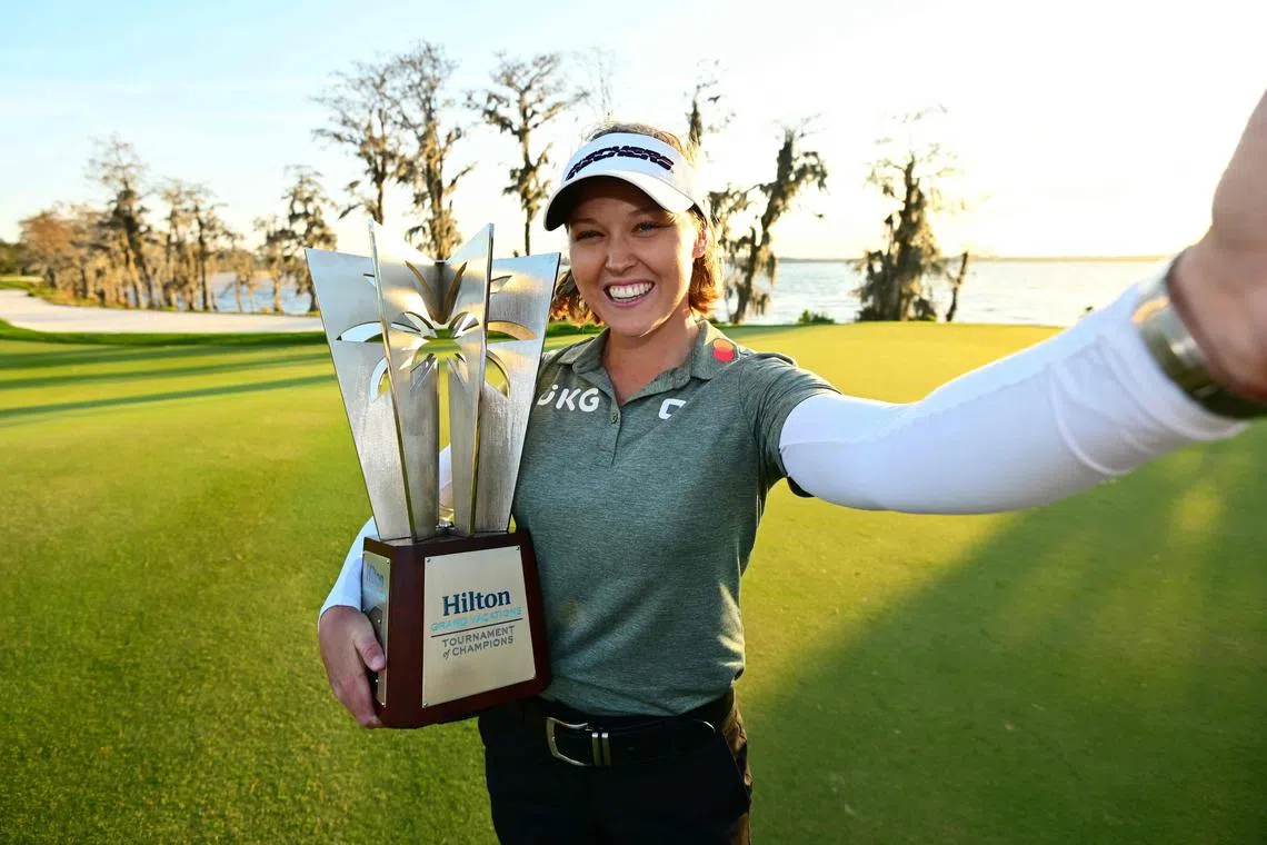 Brooke Henderson of Canada imitates a “selfie” as she poses with the trophy after winning the Hilton Grand Vacations Tournament of Champions at Lake Nona Golf & Country Club in Orlando, Florida.