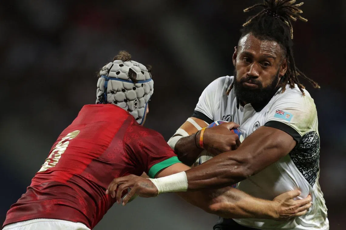 Fiji's outside centre and captain Waisea Nayacalevu is being tackled by Portugal's flanker David Wallis as he runs with the ball during the 2023 Rugby World Cup Pool C match between Fiji and Portugal at the Stade de Toulouse in Toulouse on Oct 8.