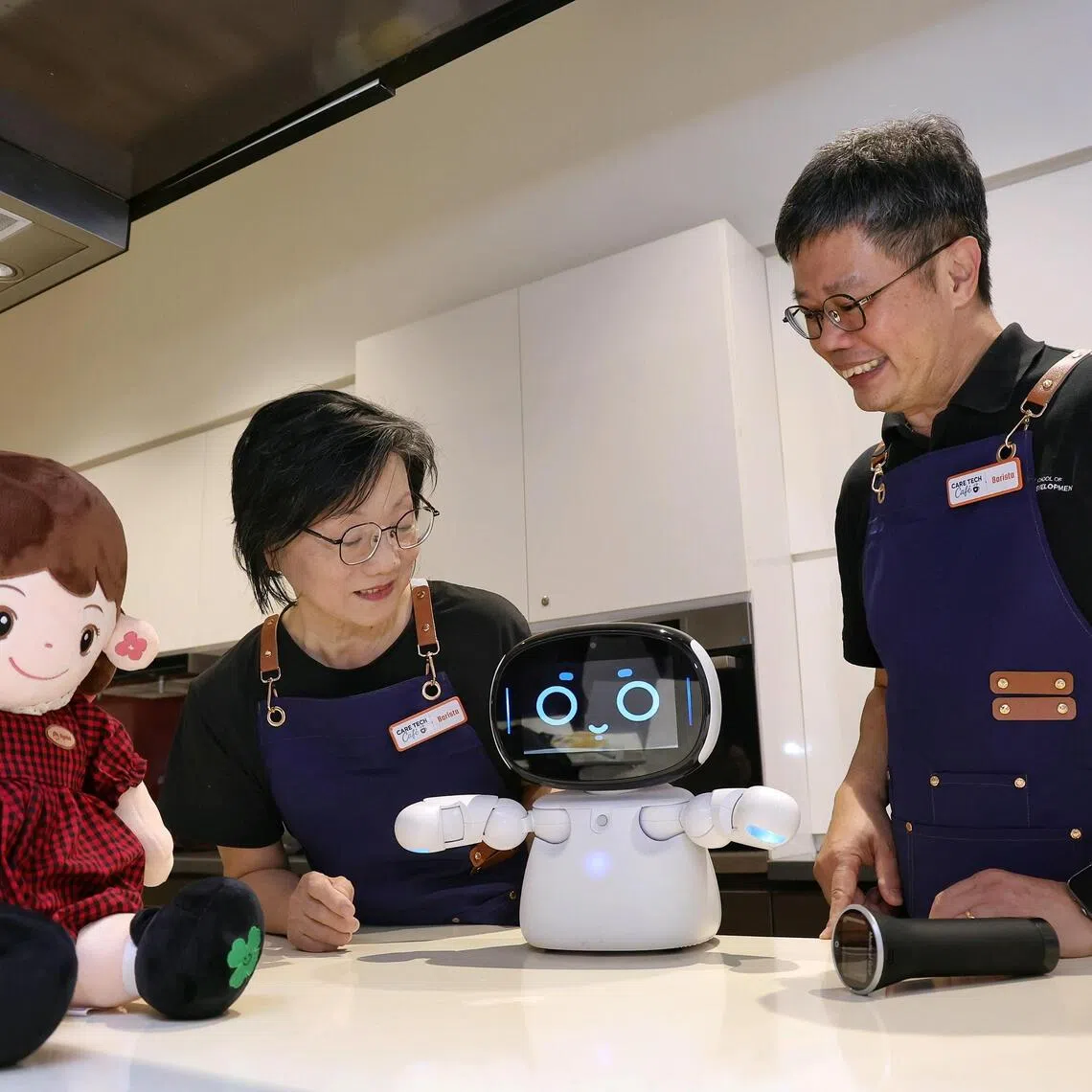 SUSS associate professor Kelvin Tan (right) explaining the features of a robot to Kampong Chai Chee resident Emily Choo at the Care Tech Cafe at Heartbeat@Bedok on July 31.