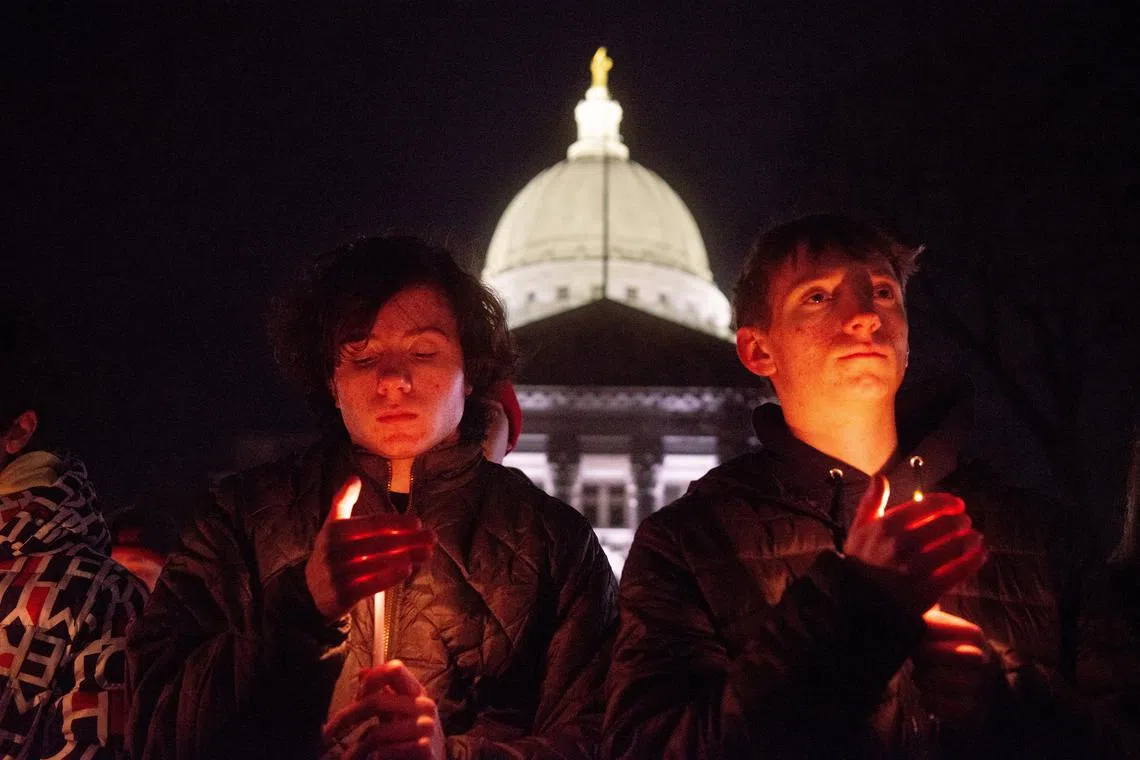 Mourners gather for a candlelight vigil at the Wisconsin State Capitol building a day after a shooting at Abundant Life Christian School, in Madison, Wisconsin, U.S. December 17, 2024.  REUTERS/Cullen Granzen