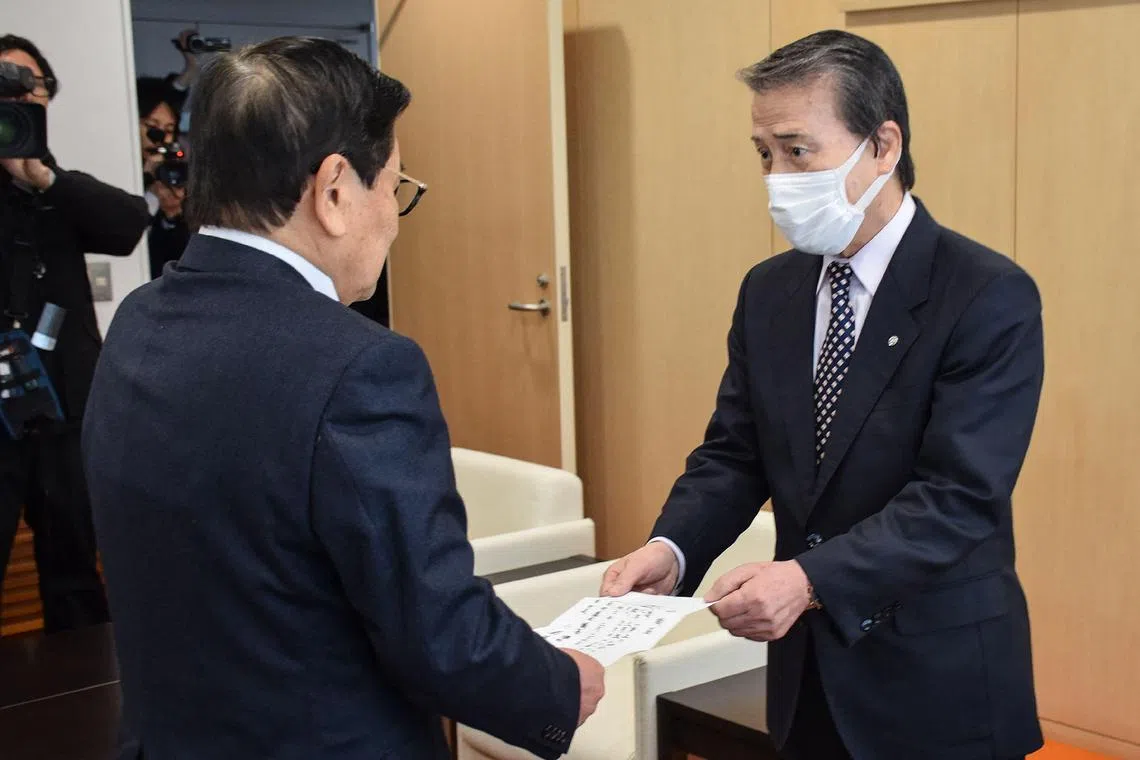 Former Japanese mayor Hideo Kojima (right) handing over his resignation in February.