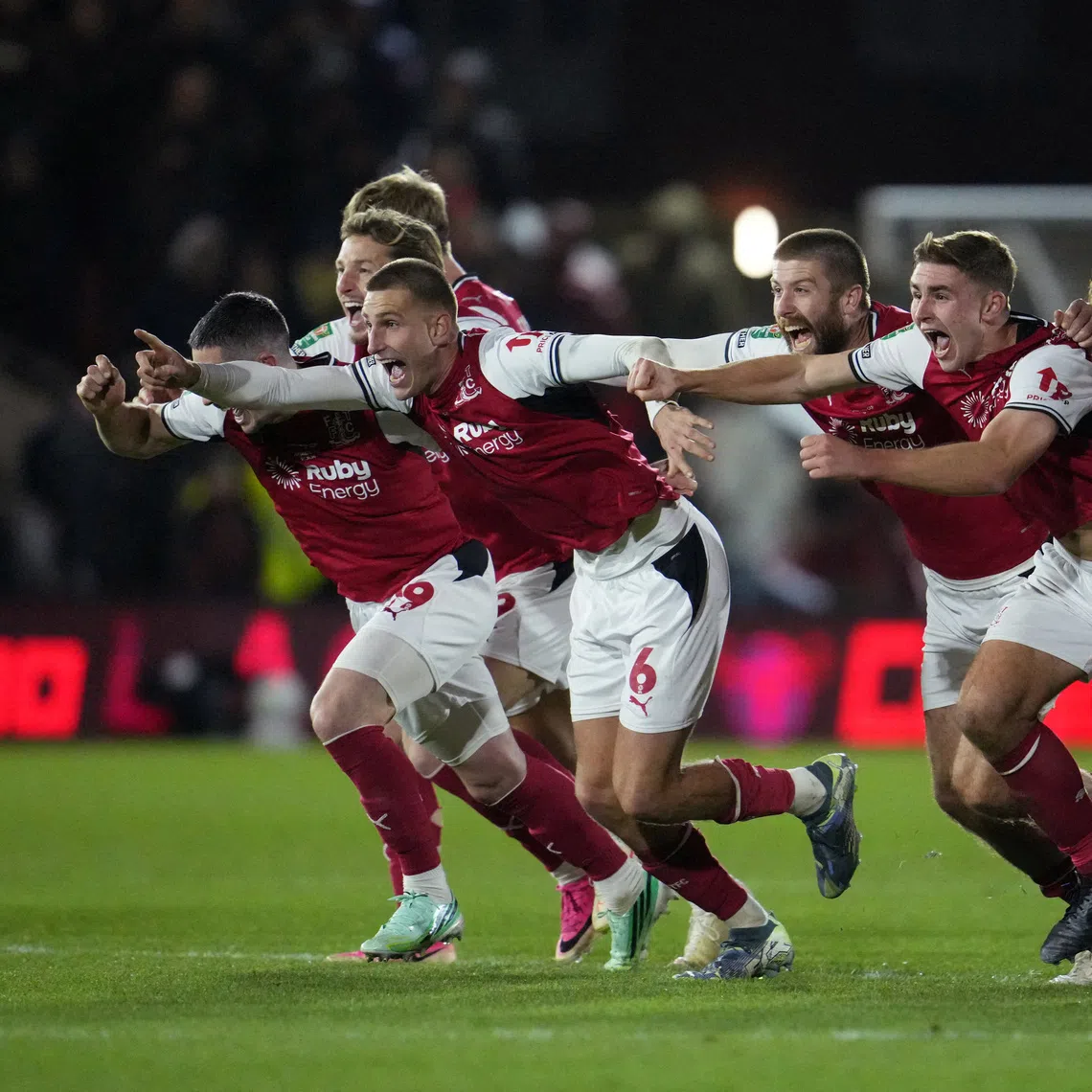 Fleetwood Town players celebrate beating Arsenal after a penalty shoot-out.