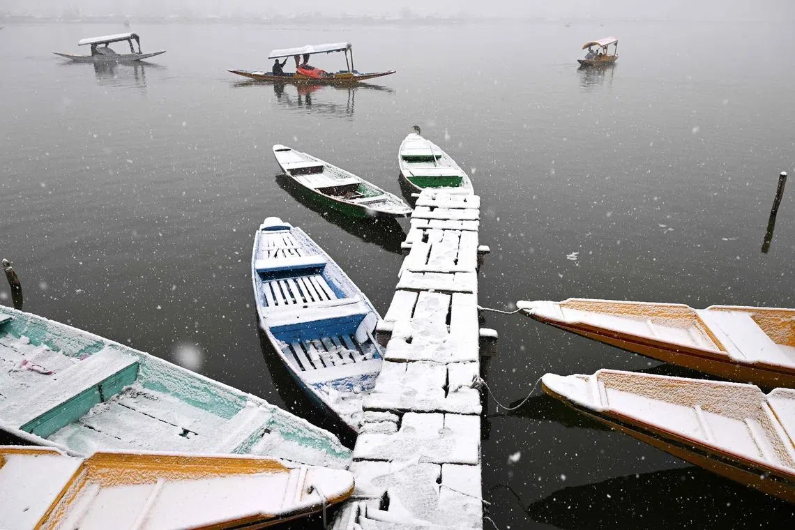 A boatman steering his shikara during a spell of fresh snowfall at the Dal lake in Srinagar, India on Jan 27, 2026. 