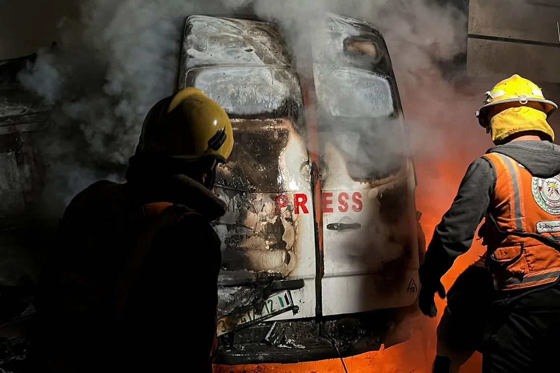 Civil Defense members put out a fire in a broadcast van following an Israeli strike that killed five journalists of Al-Quds Al-Youm television channel, according to medics with the Gaza health authorities, in the vicinity of Al-Awda hospital in Nuseirat in central Gaza December 26, 2024. REUTERS/Khamis Said