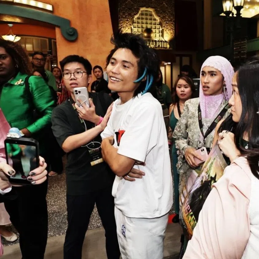 Event crasher Johnson Wen (in white) committed the offence at Universal Studios Singapore on Nov 13. During the commotion, a protective Cynthia Erivo (in black) forced herself between Ariana Grande (in light blue) and Wen, as security guards quickly nabbed him.