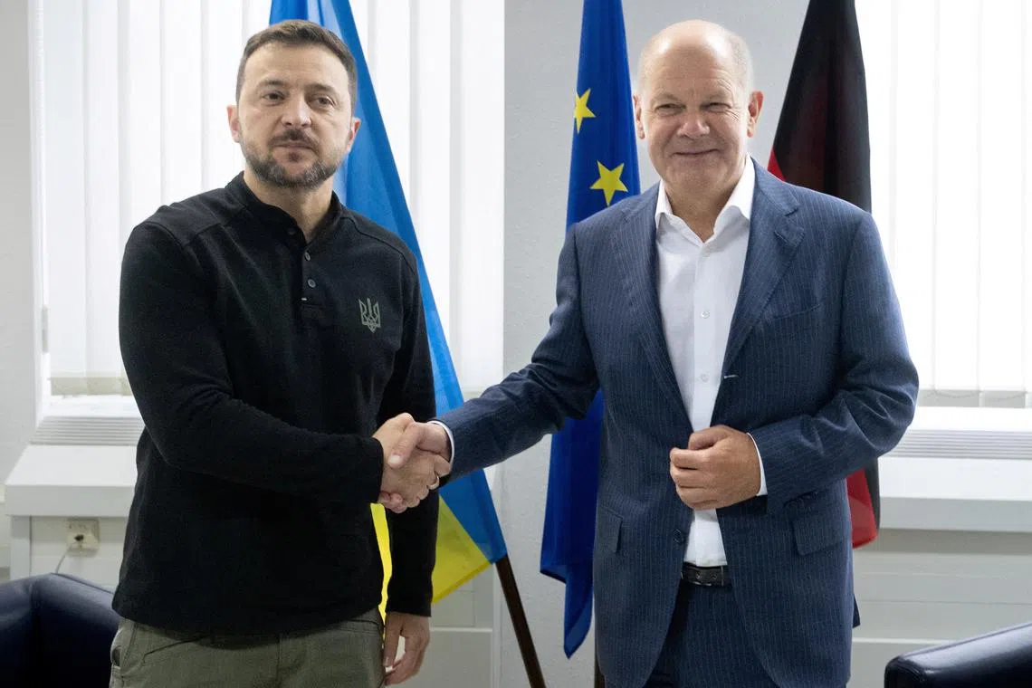 FILE PHOTO: German Chancellor Olaf Scholz and Ukrainian President Volodymyr Zelenskiy shake hands at the airoprt in Frankfurt, Germany, September 6, 2024.     Boris Roessler/Pool via REUTERS/File Photo