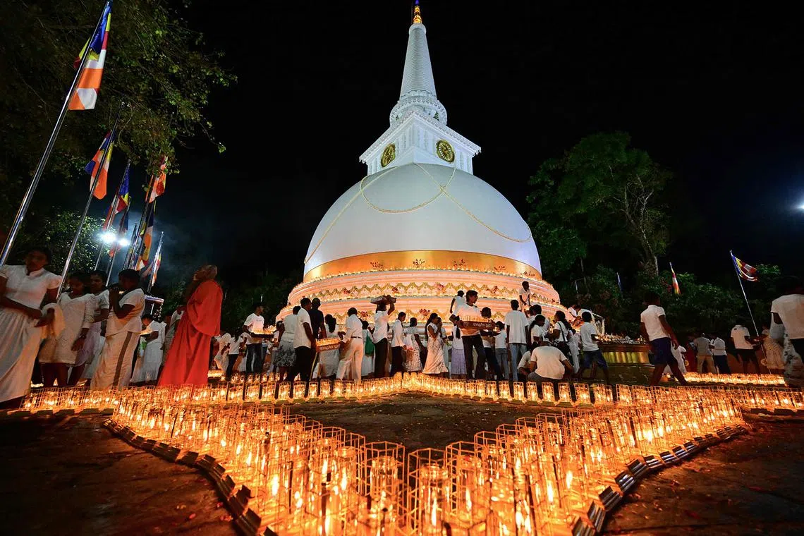 People gather during a commemorative function for the victims of the 2004 tsunami disaster, marking its 20th anniversary at the Mahamevnawa Buddhist Monastery in Galle on December 26, 2024. Emotional ceremonies began across Asia on December 26 to remember the 220,000 people who died two decades ago when a tsunami devastated coastal areas around the Indian Ocean, in one of the worst natural disasters in human history. (Photo by Ishara S. KODIKARA / AFP)