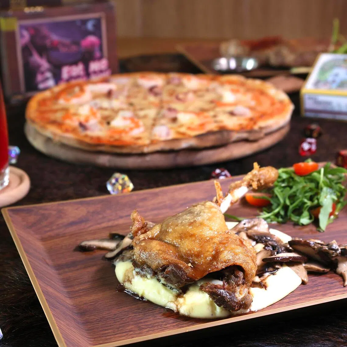 (Clockwise from left) Magic potion-inspired drink Helixir, mentaiko prawn pizza and duck confit at mediaeval fantasy-themed restaurant, Bondfire Tavern.