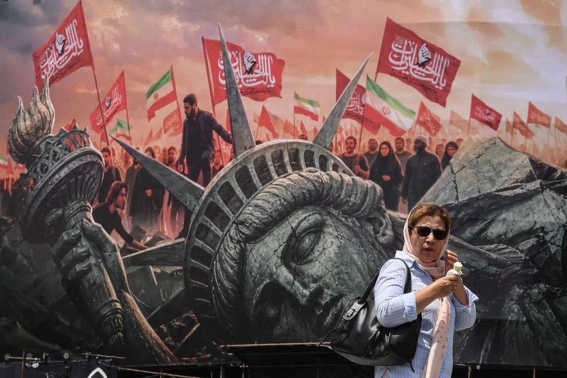 An Iranian woman walking past an anti-US billboard at Enghelab Square in central Tehran on Aug 3.