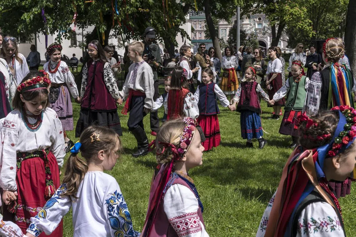 Children in traditional Ukrainian costumes enjoy Orthodox Easter festivities in Kyiv, in May 2024.