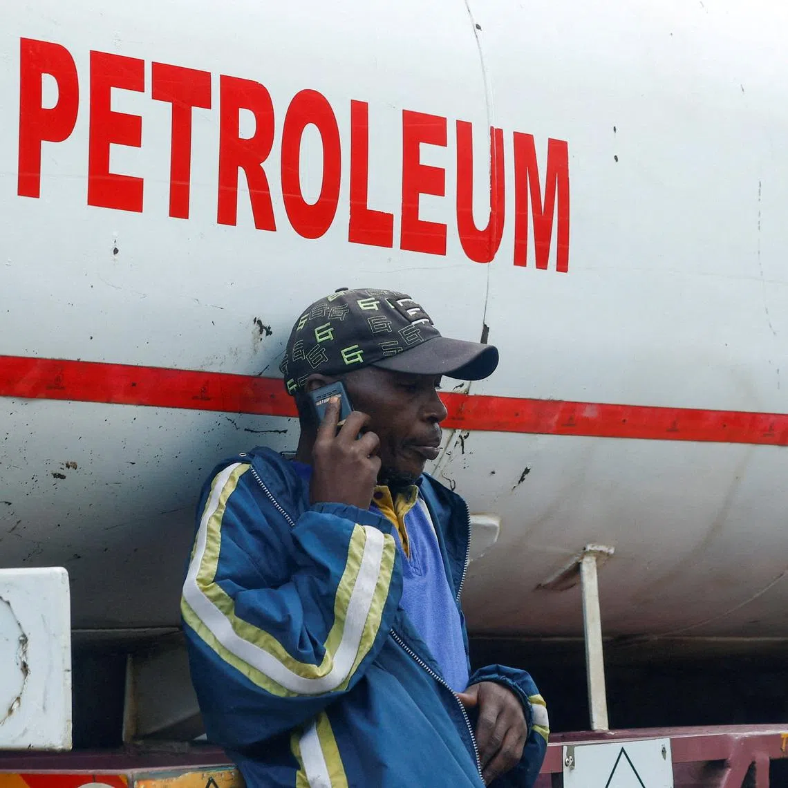 FILE PHOTO: A dealer talks on his mobile phone as fuel tankers queue outside the Kenya Pipeline Company (KPC) depot to re-fuel their commercial supplies, amid the U.S.-Israeli conflict with Iran, in the Industrial Area district of Nairobi, Kenya March 24, 2026. REUTERS/Thomas Mukoya/File Photo