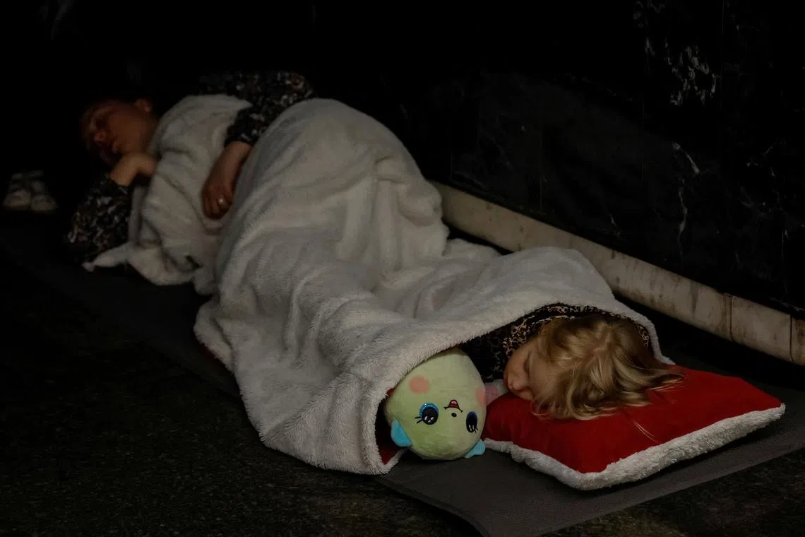 A girl sleeps with her toy as she takes shelter with her family inside a metro station during a Russian military attack, amid Russia's attacks on Ukraine, in Kyiv, Ukraine, June 1, 2024. REUTERS/Alina Smutko