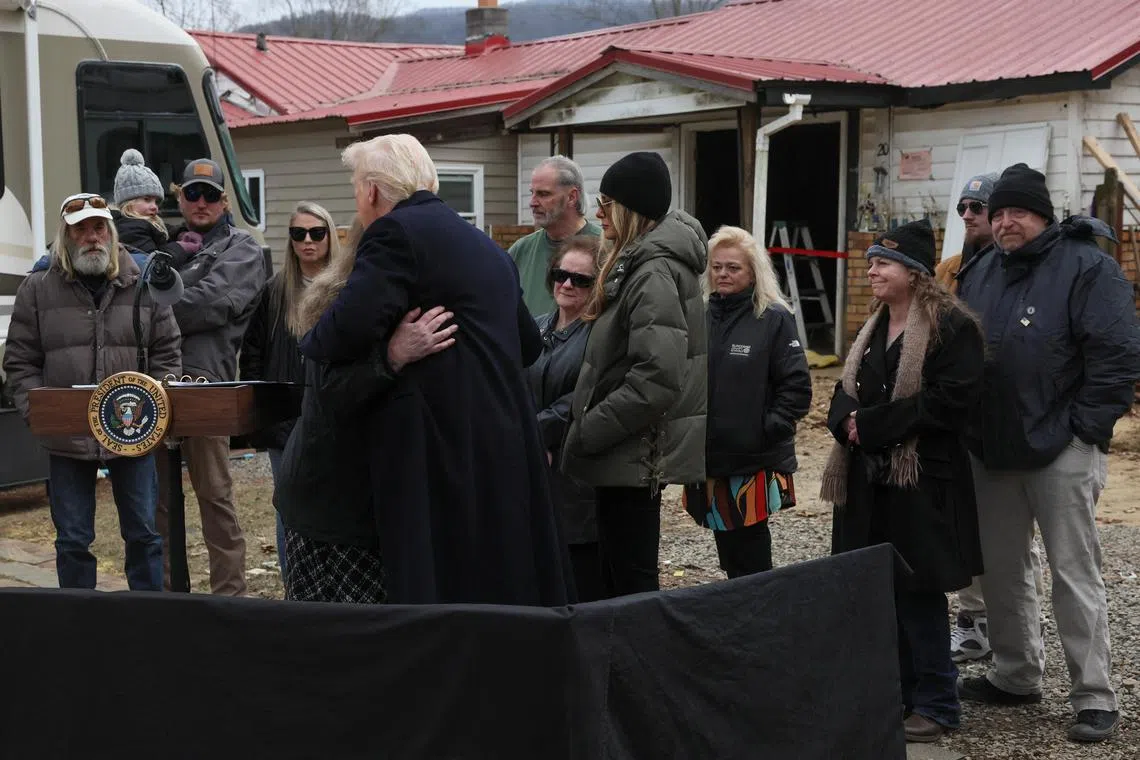 US First Lady Melania Trump looks on as US President Donald Trump hugs a woman affected by September's Hurricane Helene, in Swannanoa, North Carolina, on Jan 24.