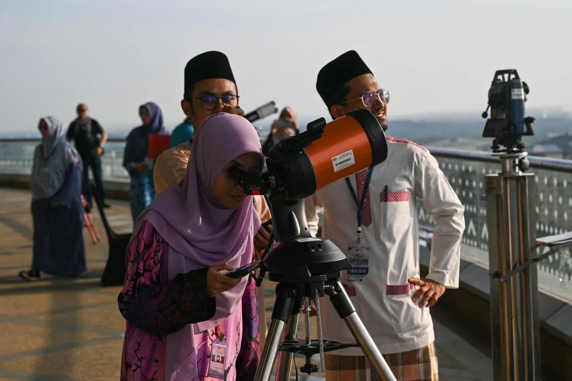 An official using a telescope to perform "rukyah", the sighting of the new moon for Ramadan, in Putrajaya on March 22, 2023. 
