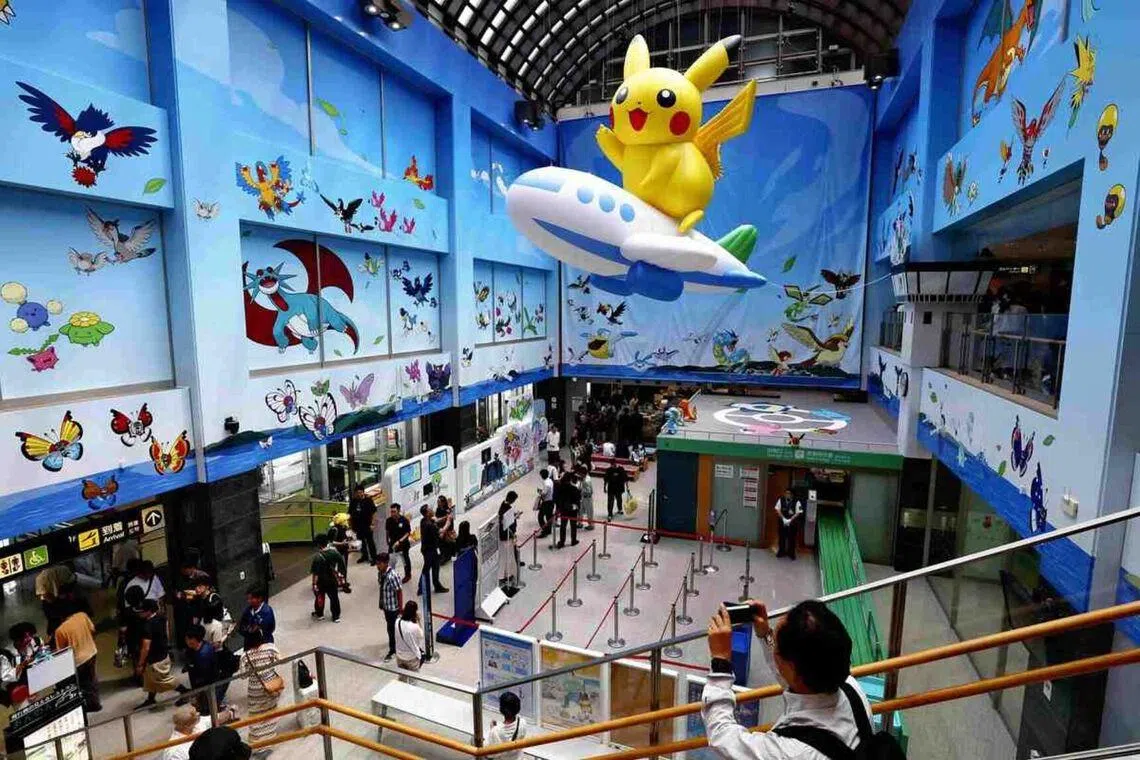 Inside the terminal, a giant Pikachu riding a balloon airplane is suspended from the atrium ceiling.