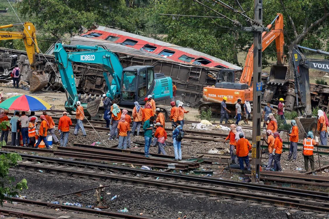 Repair crew removing the damaged coaches from the railway tracks at the site of a train collision in Odisha, India, on June 4, 2023. 
