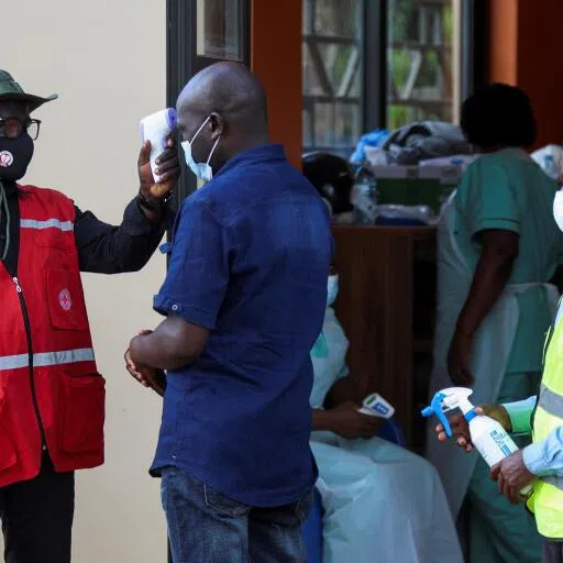 A member of the Uganda Red Cross checking the temperature of a parishioner attending a mass on June 3 at the Basilica of the Uganda Martyr near Kampala, Uganda.