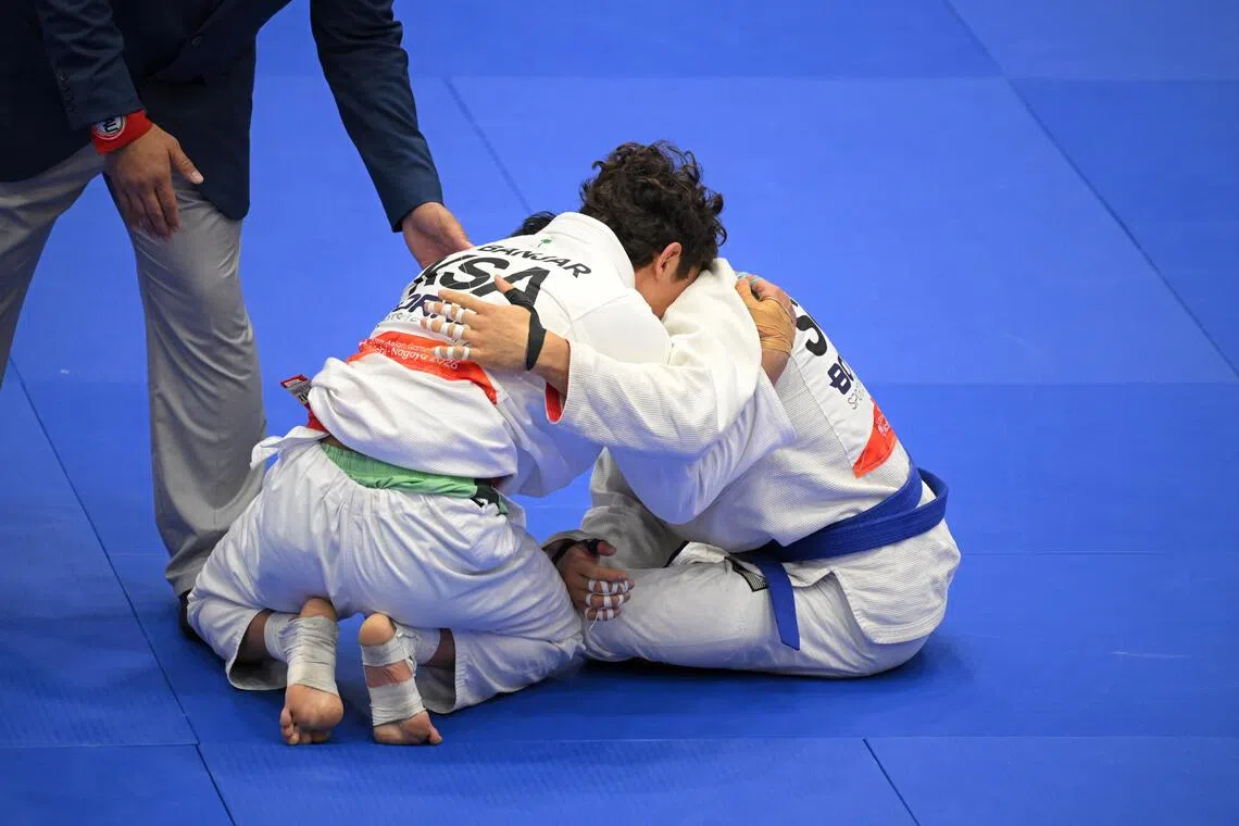 Singaporean Noah Lim (right) embraces Saudi Arabian opponent Elyas Zwawi Y Banjar after the Asian Games Men’s Jiu Jitsu 69kg Elimination Round of 16 in which he won, at the Aichi Prefectural Martial Arts Hall on Oct 1, 2026.