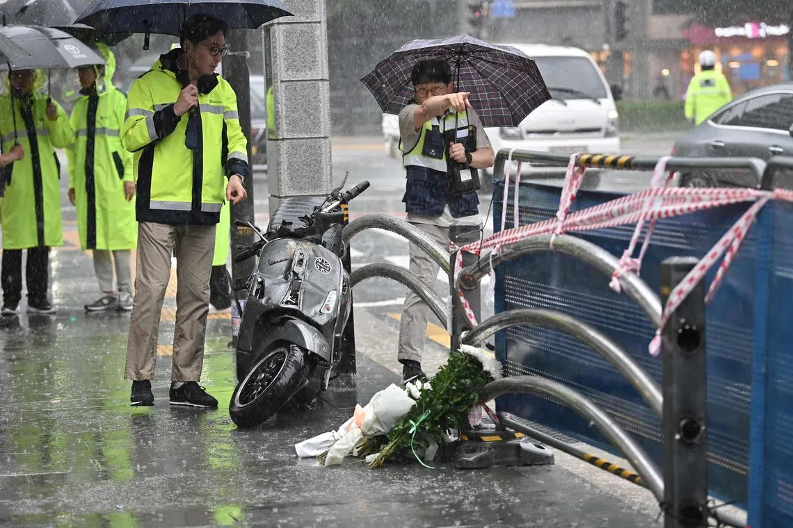 Policemen and Korea Road Traffic Authority officials investigate at the site of a car accident, which left at least nine people dead, in Seoul on July 2, 2024.