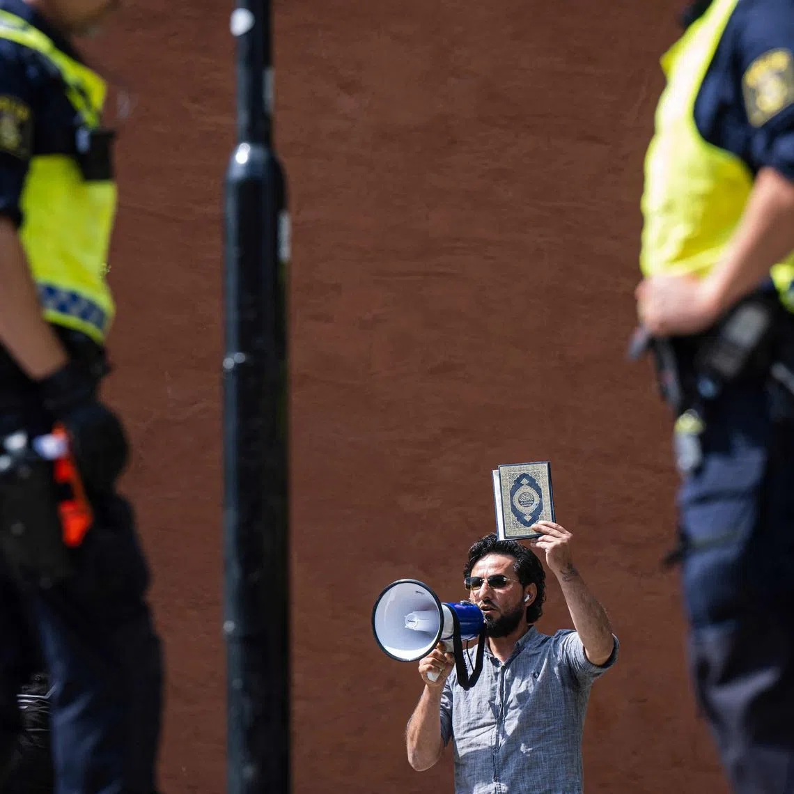 (FILES) Salwan Momika protests outside a mosque in Stockholm on June 28, 2023, during the Eid al-Adha holiday. Momika, who repeatedly burnt the Koran in 2023 in Sweden, sparking outrage in Muslim countries, has been shot dead, media reported on January 30, 2025, with police confirming a man died in a shooting the day before. A Stockholm court was due to rule on January 30, 2025 whether Salwan Momika, a Christian Iraqi who burned Korans at a slew of protests, was guilty of inciting ethnic hatred. It postponed the ruling, saying "one of the defendents has died." (Photo by Jonathan NACKSTRAND / AFP)