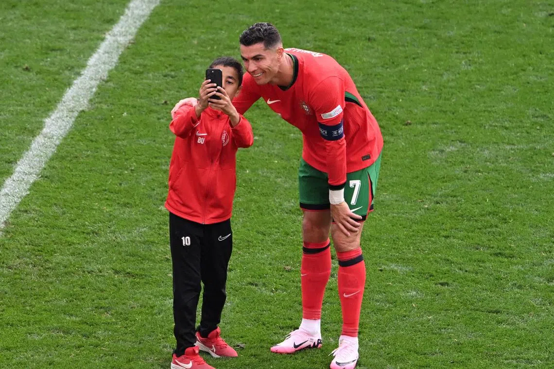 FILE PHOTO: Soccer Football - Euro 2024 - Group F - Turkey v Portugal - Dortmund BVB Stadion, Dortmund, Germany - June 22, 2024 Young pitch invader takes a selfie with Portugal's Cristiano Ronaldo REUTERS/Carmen Jaspersen/File Photo