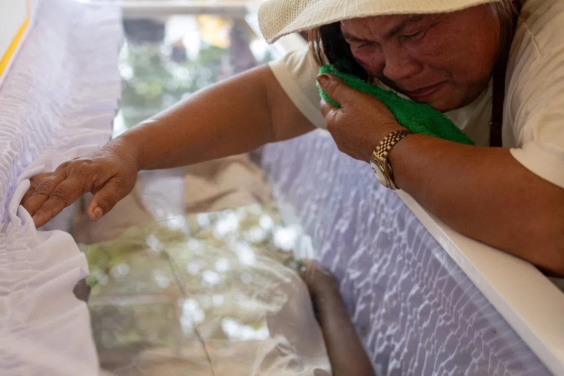 The aunt of Lady Jane Ytang, 17, who died during the magnitude 6.9 quake, mourns over her coffin at a wake for victims in Bogo, Cebu, Philippines, October 2, 2025. REUTERS/Eloisa Lopez